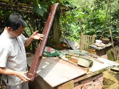 Ma Yuesi (kiri) mengecek Guqin, alat musik tradisional China, di kediamannya di Desa Yalan, Distrik Yuhang, Hangzhou, Provinsi Zhejiang, China timur, pada 30 Juni 2020. Ma Yuesi (58) memutuskan menjadi pembuat Guqin sejak berusia 24 tahun. (Xinhua/Weng Xinyang)