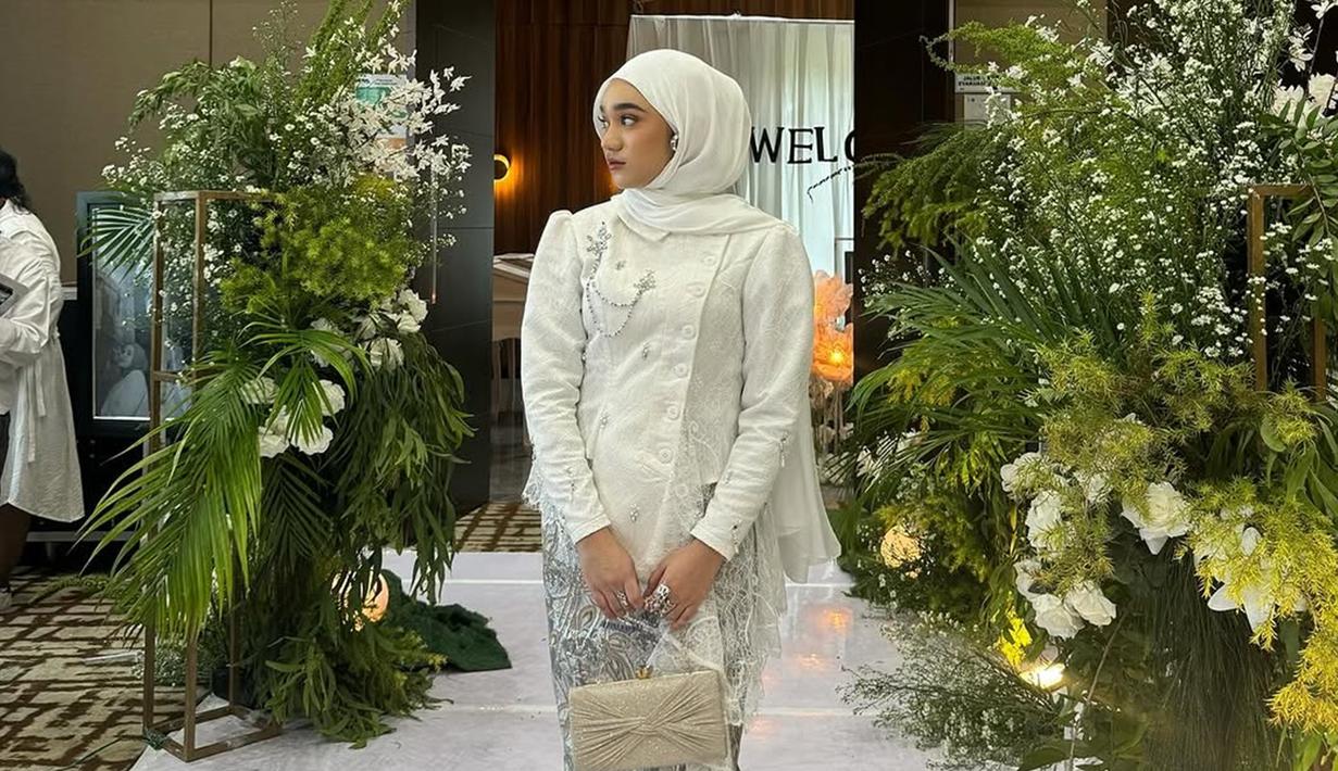 Penampilannya manglingi dan tak kalah memesona dari Salma Salsabil sang pengantin, diketahui nama Nabila Taqiyyah sampai trending di X (Twitter) beberapa waktu lalu. Berbeda dengan warna kebaya yang dikenakannya, penyanyi berusia 19 tahun ini meneteng tas warna cokelat dengan aksen pita dan memakai heels warna silver yang warnanya senada dengan kain batiknya. (Liputan6.com/IG/@nabilataqiyyah)