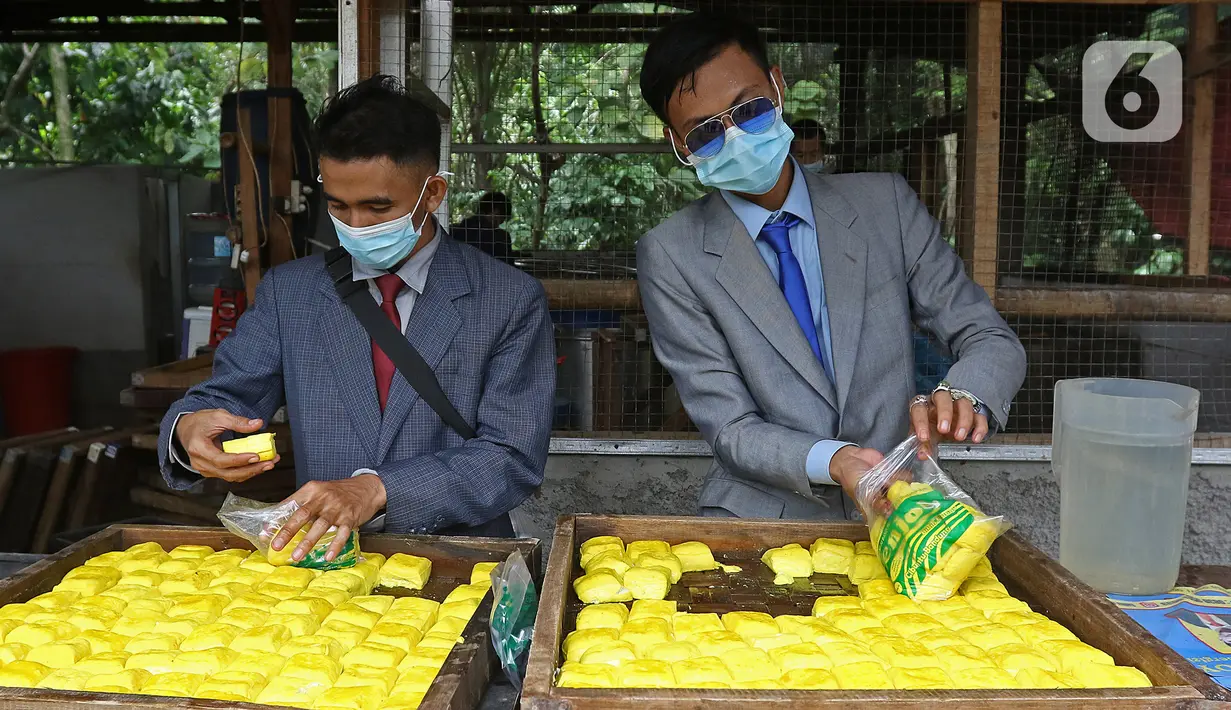 Pekerja memproduksi tahu dengan pakaian seperti pekerja kantoran di daerah Sukaraja, Bogor, Senin (14/12/2020). Ide ini untuk membangkitkan semangat dan kepercayaan diri agar termotivasi menjadi pekerja yang sukses dan menarik minat pembeli di tengah persaingan ketat. (Liputan6.com/Herman Zakharia)