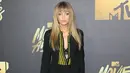 Model cantik, Gigi Hadid berpose di karpet merah acara MTV Movie Awards di Warner Bros Studio, Burbank, California, Sabtu (9/4).  Gigi Hadid tampil chic dibalut setelan blazer hitam bergaris dan heels hitam. (Jean BAPTISTE LACROIX/AFP)