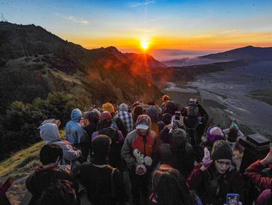 Pengunjung memadati Love Hill menunggu matari terbit di Bromo, Jawa Timur. Gunung Bromo dikenal sebagai salah satu lanskap paling magis di Indonesia. Perpaduan antara gunung megah, lautan pasir luas, serta kabut tipis yang menari di pagi hari menciptakan panorama emas yang sulit ditandingi. (merdeka.com/Arie Basuki)