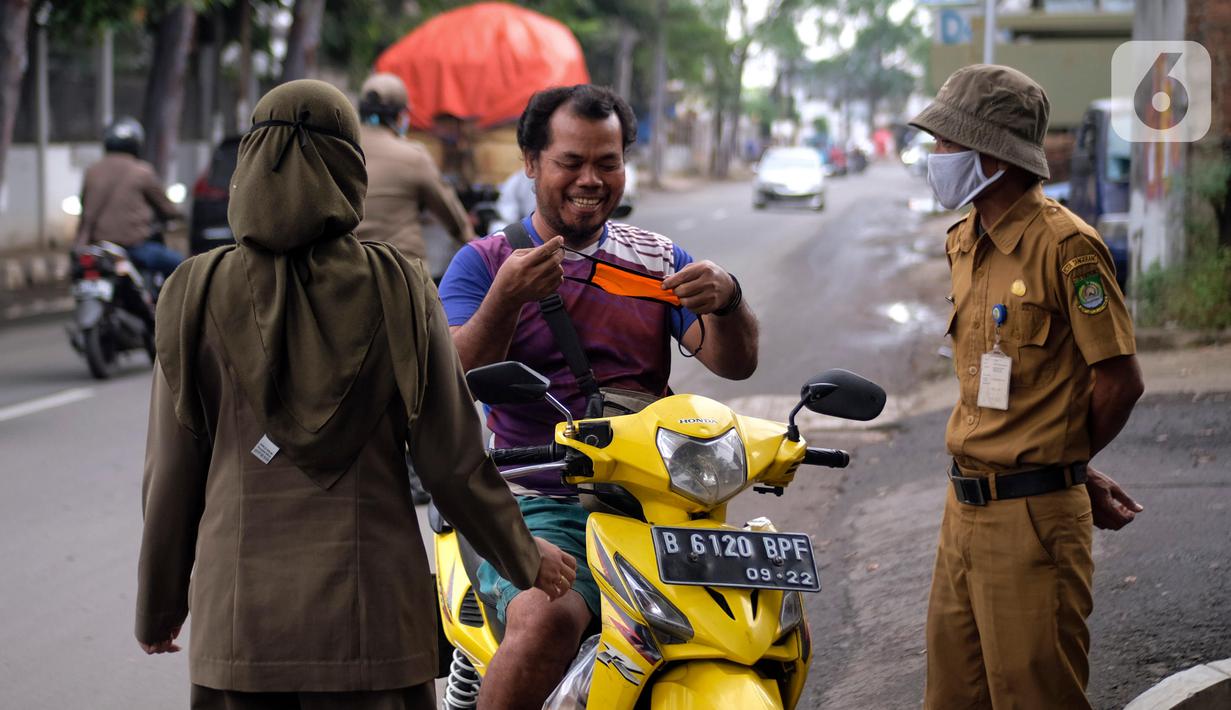 Petugas merazia warga yang tidak mengenakan masker di Kelurahan Cimone, Kota Tangerang, Banten, Rabu (15/7/2020). Guna memberi efek jera, Pemkot Tangerang memberlakukan sanksi sosial kepada pelanggar PSBB seperti menyapu dengan memakai rompi bertulis ‘Pelanggar PSBB’. (Liputan6.com/Angga Yuniar)