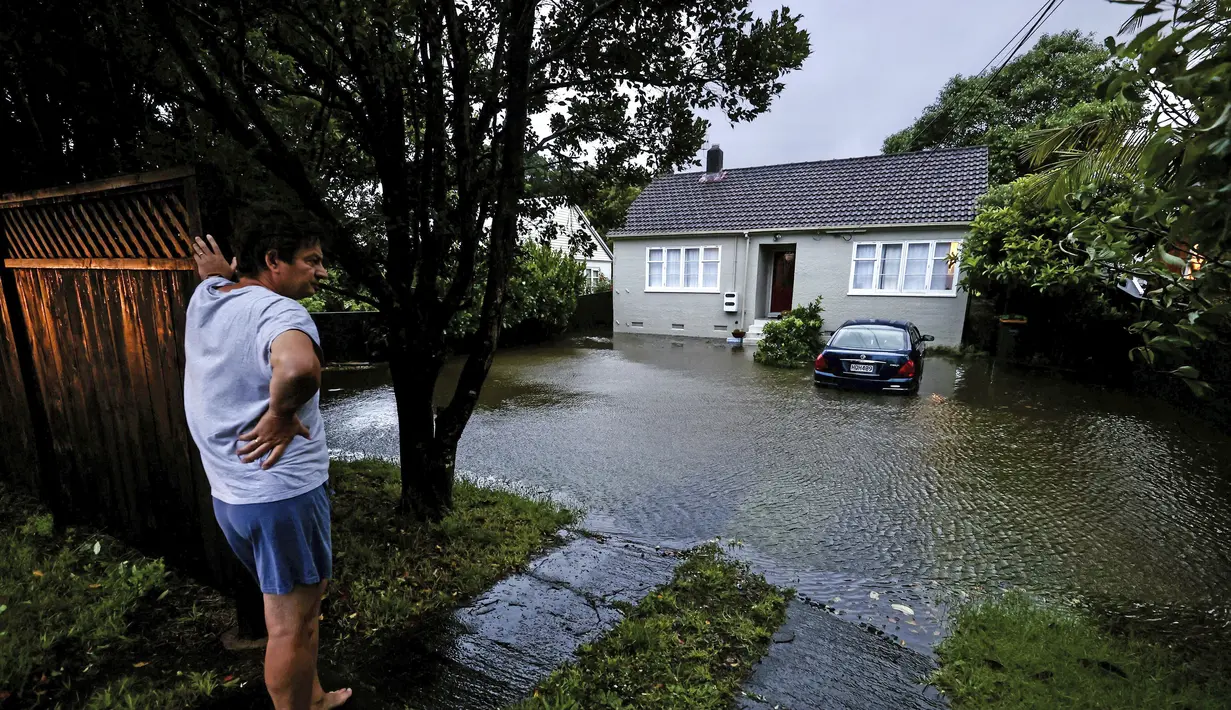 Seorang pria meninjau kerusakan akibat banjir di luar rumahnya di Auckland, Selandia Baru, Rabu (1/2/2023). Peringatan hujan lebat untuk Auckland dicabut, meskipun keadaan darurat tetap berlaku untuk kota terbesar di negara itu setelah curah hujan dan banjir yang mencapai rekor. pada hari Jumat menewaskan empat orang dan menyebabkan gangguan yang meluas. (Brett Phibbs/New Zealand Herald via AP)