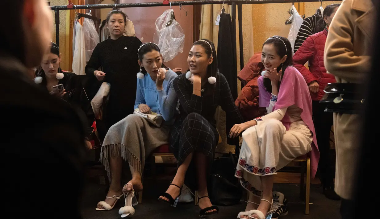 Sejumlah model berbincang di belakang panggung sebelum tampil membawakan koleksi Rabbit-Warm karya Zhuang Ganran selama China Fashion Week di Beijing (30/10). (AFP Photo/Nicolas Asfouri)