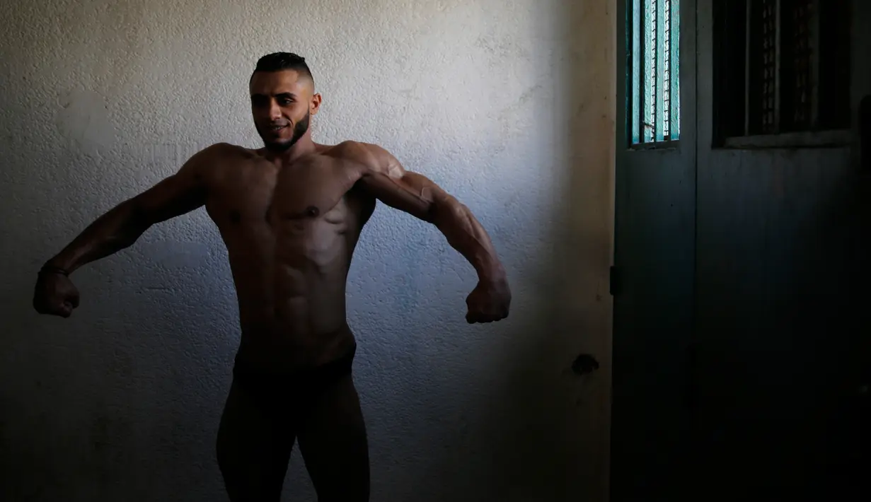 Seorang kontestan mempersiapkan diri sebelum tampil di atas panggung kompetisi binaraga lokal di Kota Gaza pada Minggu (15/9/2019). Kompetisi ini diikuti oleh sejumlah pria Palestina. (AP Photo/Hatem Moussa)