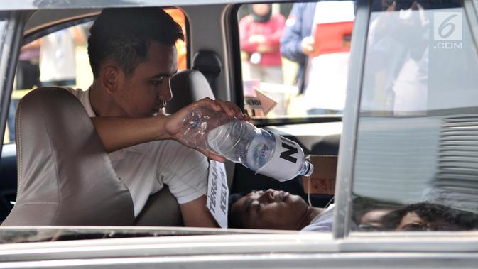 Model yang memerankan tersangka Kelvin memeragakan adegan kasus istri bunuh dan bakar suami serta anak tiri di Polda Metro Jaya, Jakarta, Senin (9/9/2019). Model yang memerankan tersangka Kelvin dan tersangka Aulia Kesuma memeragakan tiga adegan pembakaran korban di mobil. (merdeka.com/IqbalNugroho)