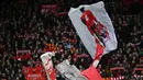 Fans Liverpool mengibarkan bendera bergambarkan Virgil van Dijk pada laga lanjutan Liga Inggris 2022/2023 melawan Manchester United di Anfield, Liverpool, Inggris, 5 Maret 2023. (AFP/Paul Ellis)