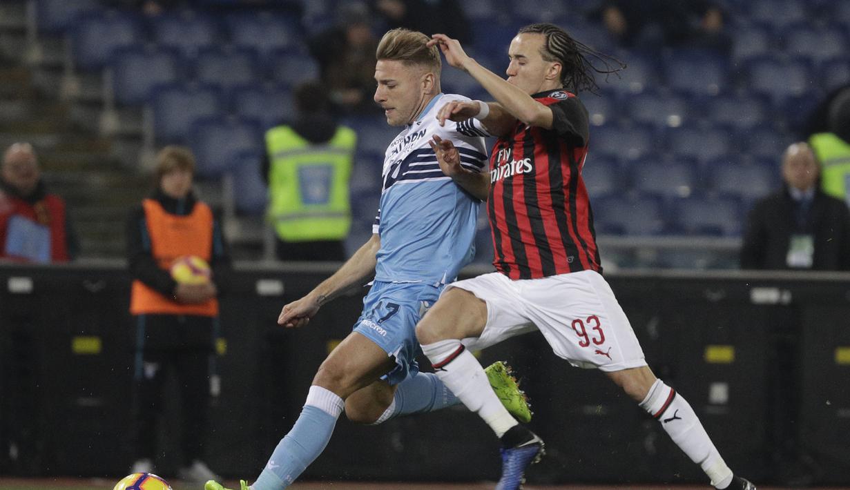 Pergerakan Immobile yang coba dihadang Diego Laxalt pada laga semifinal Coppa Italia yang berlangsung di stadion Olimpico, Roma, Rabu (27/2). AC Milan bermain imbang 0-0 kontra SS Lazio. (AP Newsroom)