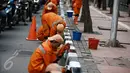 Petugas dari Kelurahan Karet Semanggi mengecat trotoar di kawasan Jalan Semanggi, Jakarta, Selasa (1/3/2016). Trotoar itu dipercantik dengan dicat ulang oleh Petugas Prasarana Sarana Umum (PPSU). (Liputan6.com/Faizal Fanani)
