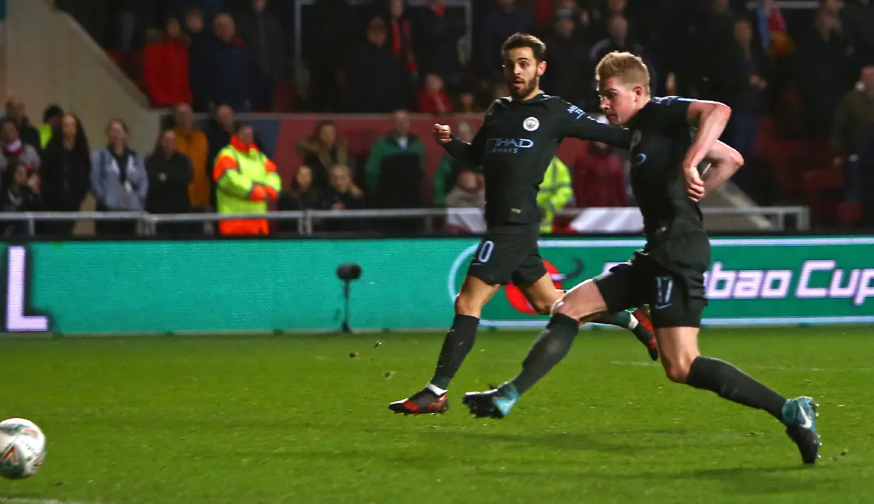 Pemain Manchester City, Kevin De Bruyne (kanan) mencetak gol ke gawang Bristol City pada leg kedua semifinal Piala Liga di Ashton Gate, Rabu (24/1). Manchester City menang tipis 3-2 dan memastikan diri lolos ke final. (Geoff CADDICK/AFP)