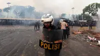 Polisi menghalau mahasiswa dalam demonstrasi menolak pengesahan RUU KUHP dan revisi UU KPK di depan Gedung DPR, Jakarta, Selasa (24/9/2019). Mahasiswa lari tunggang langgang setelah aparat kepolisian menembakkan gas air mata dan water cannon. (Liputan6.com/JohanTallo)