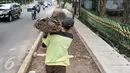 Pekerja memanggul tanah ketika menyelesaikan pembangunan trotoar di Jalan Raya Ragunan, Jakarta, Rabu (12/10). Sudin Bina Marga Jaksel menganggarkan Rp79 miliar untuk pembangunan dan perbaikan trotoar di 10 kecamatan Jaksel. (Liputan6.com/Yoppy Renato)