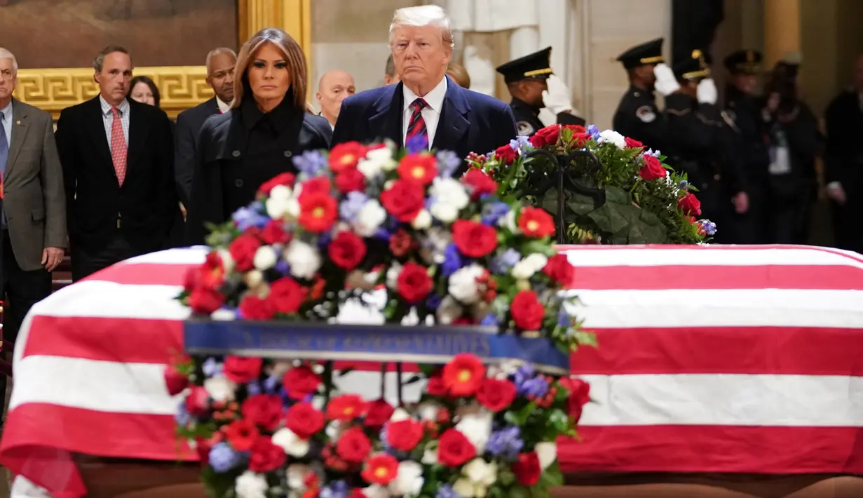 Presiden AS, Donald Trump bersama Melania Trump tiba untuk memberikan penghormatan terakhir kepada George HW Bush di Gedung Capitol, Washington, Senin (3/12). Bush senior meninggal dunia pada Jumat, 30 November 2018, di usia ke-94. (MANDEL NGAN/ AFP)