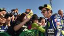 Valentino Rossi dikelilingi penggemarnya di paddock sebelum latihan bebas GP Jepang di Sirkuit Motegi, Jepang, (9/10/2015). (AFP Photo/Kazuhiro Nogi)