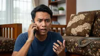 Ilustrasi seorang pria yang menghubungi layanan darurat karena di rumahnya ada ular. Foto: Gemini