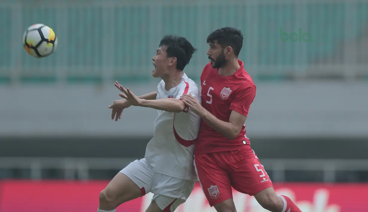 Pemain Bahrain U-23, Hamed Alshamsan (kanan)  berebut bola dengan pemain Korea Utara U-23 pada laga PSSI Anniversary Cup 2018 di Stadion Pakansari, Bogor, (03/5/2018). Bahrain unggul sementara 1-0. (Bola.com/Nick Hanoatubun)