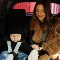 ibu sedang memasangkan car seat untuk anaknya. credits: freepik