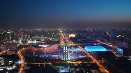 National Aquatics Center yang dikenal sebagai Ice Cube (kanan) venue untuk curling pada Olimpiade Musim Dingin 2022 dan National Stadium yang dikenal sebagai Bird's Nest (kiri) terlihat di Beijing, 3 Januari 2022. Olimpiade Musim Dingin 2022 akan dibuka pada 4 Februari mendatang. (GREG BAKER/AFP)