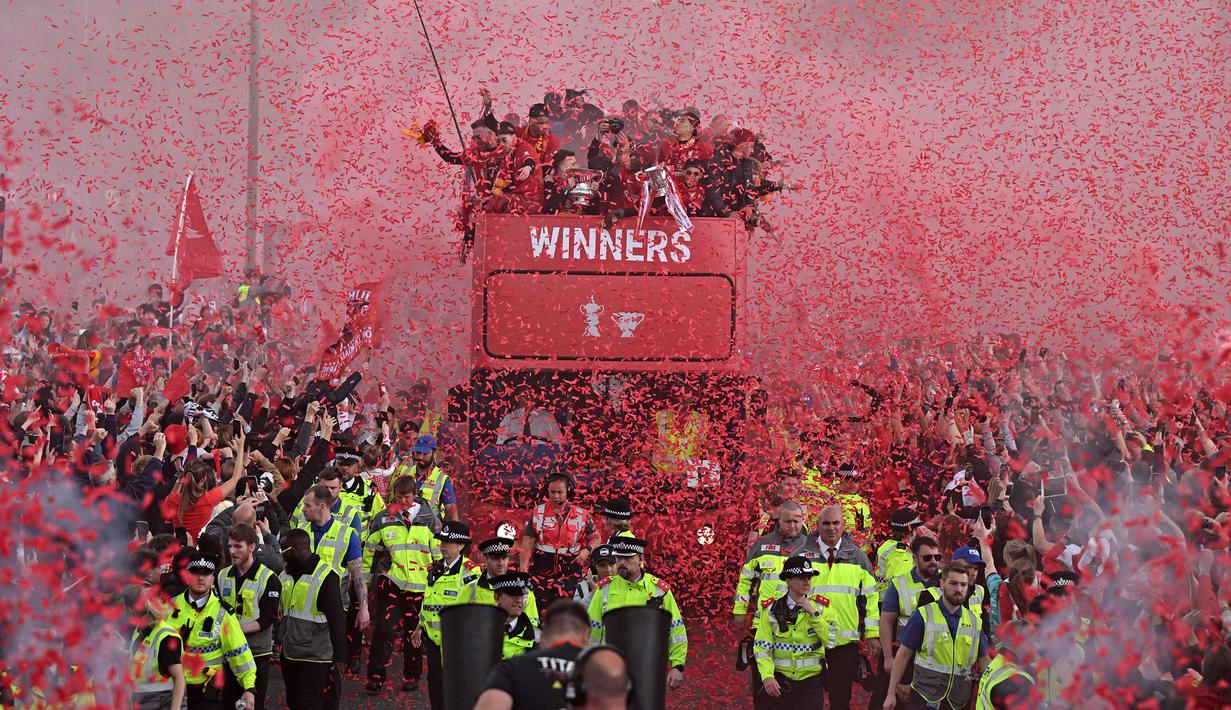 Ribuan fans Liverpool memadati jalan-jalan kota untuk menyambut tim kebanggaan mereka yang melakukan parade di atas bus terbuka pada Minggu (29/05/2022) waktu setempat. Musim ini, The Reds berhasil meraih dua trofi yaitu Piala FA dan Piala Liga Inggris. (AFP/Oli Scarff)