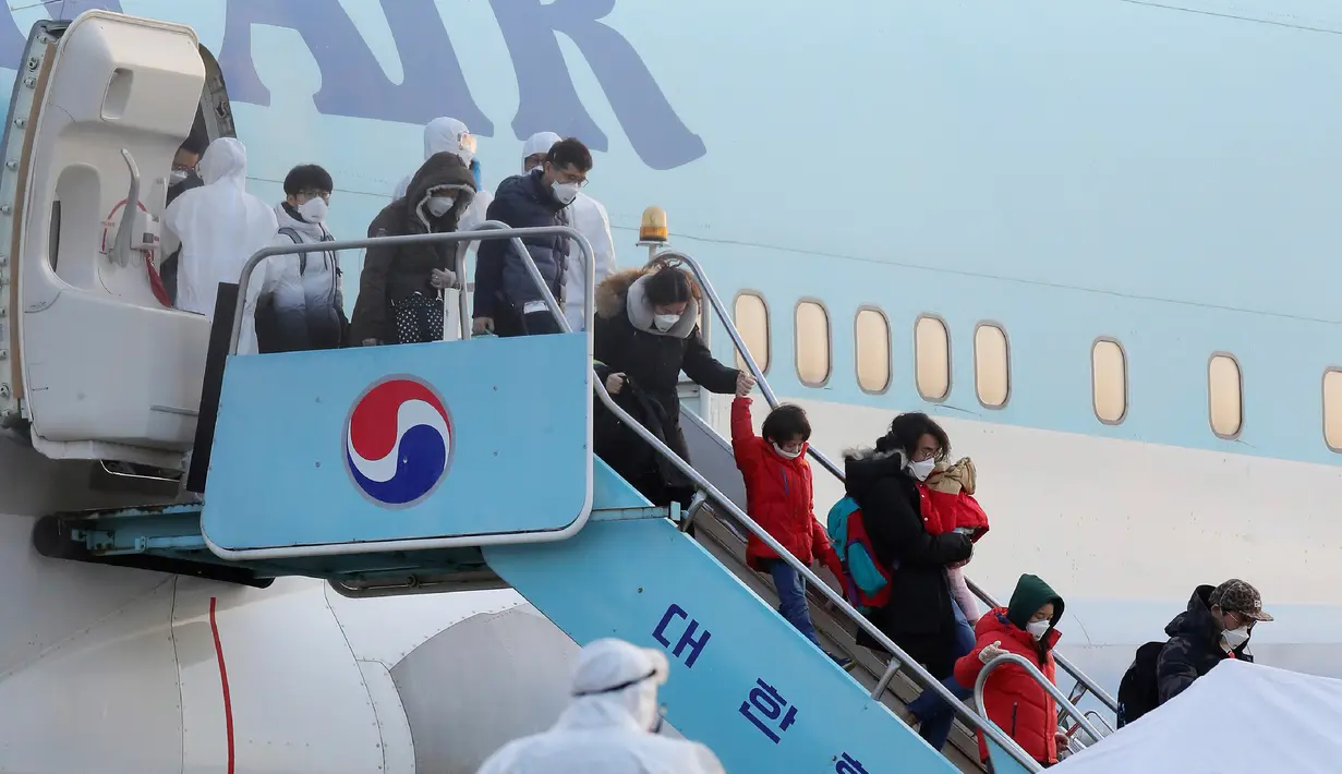 Warga Korea Selatan yang dievakuasi dari dari Wuhan, China, menuruni pesawat charter di Bandara Internasional Gimpo di Seoul pada Jumat (31/1/2020). Pesawat sewaan tersebut membawa pulang 367 warga negara Korea Selatan dari Wuhan, pusat wabah virus corona. (Kim Kyun-hyun/Newsis via AP)