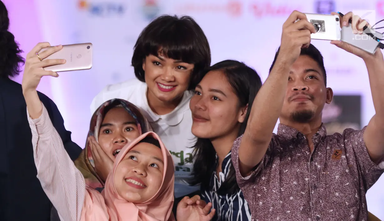 Pemeran emak dalam film Keluarga Cemara, Nirina Zubir berswafoto dengan peserta EGTC 2018 di Graha Sanusi Hardjadinata, Universitas Padjajdaran, Bandung, Rabu (5/12). Mereka bercerita seputar pembuatan film tersebut. (Liputan6.com/Helmi Fithriansyah)