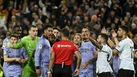 Wasit Spanyol Jesus Gil Manzano (belakang) berbicara dengan gelandang Inggris Real Madrid #5 Jude Bellingham selama pertandingan sepak bola liga Spanyol antara Valencia CF dan Real Madrid di Stadion Mestalla, Valencia pada Minggu (3/3/2024). (JOSE JORDAN / AFP)