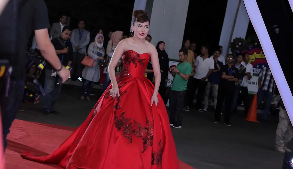 Berjalan di karpet merah, sering menjadi perhatian. Disamping itu, karpet merah sering menjadi tempat untuk memamerkan karya para desainer dalam merancang busananya. Di AMI Awards, Ayu Ting Ting hadir dengan warna merah. (Deki Prayoga/Bintang.com)