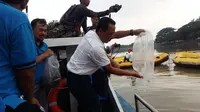Melepas ikan meruwat Kali Surabaya (Liputan6.com/Dian Kurniawan)