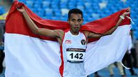 Pelari Indonesia Rikki Marthin Luther Simbolon merayakan kemenangannya pada final 10.000 m putra SEA Games 2023 di Phnom Penh, Kamboja, Kamis (11/5/2023). Rikki Marthin memenangkan pertandingan dengan catatan waktu 31 menit 8,85 detik. (MOHD RASFAN/AFP)
