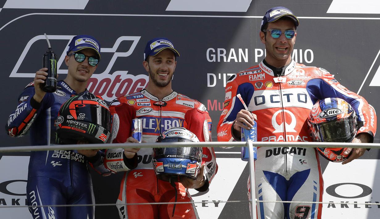 Andrea Dovizioso bersama Maverick Vinales (kiri) dan Danilo Petrucci (kanan) merayakan keberhasilan mereka meraih podium usai memenangi balapan MotoGP Italia di Sirkuit Mugello, Minggu (4/6/2017). (AP/Antonio Calanni)