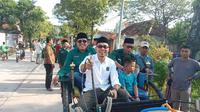 KH Ahmad Fahim Mulabby (baju putih) naik dokar di depan KPU Kabupaten Blora, Jawa Tengah. (Liputan6.com/Ahmad Adirin)