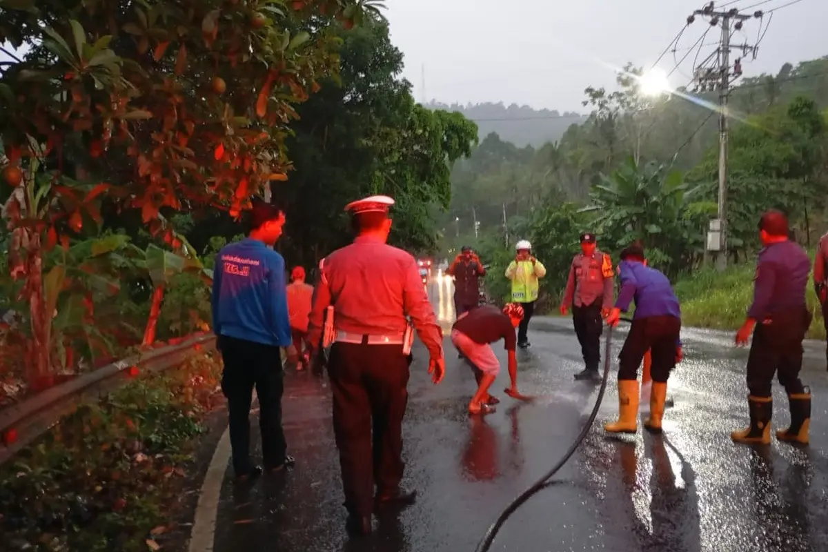 Petugas Satlantas Polresta Bandar Lampung dibantu BPBD setempat menyemprot Jalan Imba Kesuma yang terkena tumpahan solar. Foto : (Istimewa).