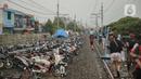 Jalur rel kereta commuterline Tangerang-Duri yang dipenuhi sepeda motor dan pengungsi banjir di Kembangan Baru, Jakarta, Jumat (3/1/2020). Jalur rel yang nonaktif sementara karena banjir dimanfaatkan warga untuk mendirikan tenda darurat karena rumah mereka masih terendam. (Liputan6.com/FaizalFanani)