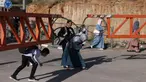 Warga Palestina membungkuk untuk menyeberangi gerbang besi yang didirikan oleh tentara Israel di Hebron, Tepi Barat yang diduduki, pada 13 Mei 2025. (HAZEM BADER/AFP)