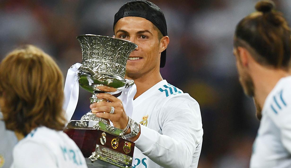 Striker Real Madrid, Cristiano Ronaldo, memegang trofi Piala Super Spanyol 2017 setelah mengalahkan Barcelona di Stadion Santiago Bernabeu, Rabu (16/8/2017). Cristiano Ronaldo meraih gelar pemain terbaik FIFA 2017. (AFP/Gabriel Bouys)