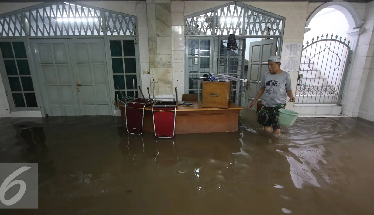 Seorang warga membersihkan banjir yang menggenangi Mesjid An Nur di kawasan Pasar Minggu, Jakarta, Selasa (4/10). Banjir yang rutin menggenangi kawasan tersebut menyebabkan aktivitas warga serta ibadah terganggu. (Liputan6.com/Immanuel Antonius)