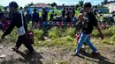 Warga membawa tabung gas di sebuah stasiun pengisian dan pembelian LPG setelah banjir bandang di Banda Aceh pada Rabu 17 Desember 2025. Kelangkaan gas masih terjadi di Kota Banda Aceh. (CHAIDEER MAHYUDDIN/AFP)