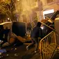 Demonstran pro kemerdekaan Catalonia merusak tempat sampah dan besi pembatas di Barcelona, Spanyol, Minggu (25/3). Demonstran memprotes penangkapan mantan pemimpin ekstrem Catalonia, Carles Puigdemont. (Foto AP/Emilio Morenatti)