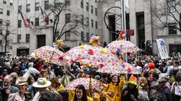 Sejumlah orang mengenakan kostum dan membawa payung saat mengikuti parade Paskah tahunan di sepanjang 5th Ave di New York City (4/1). Parade ini pun membolehkan siapa saja ikut berpartisipasi. (Stephanie Keith / Getty Images / AFP)