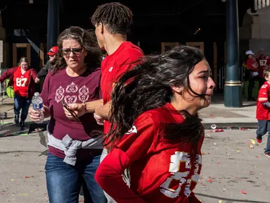 Ekspresi panik sejumlah warga saat tragedi penembakan di parade kemenangan Kansas City Chiefs setelah memenangkan Super Bowl LVIII di Kansas City, Missouri, Amerika Serikat, Rabu (14/02/2024) waktu setempat. Sebanyak 21 orang terluka dan satu orang meninggal dunia akibat teror tersebut. (AFP/Andrew Caballero-Reynolds)