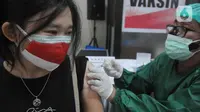 Seorang warga negara asing (WNA) disuntik vaksin covid-19 sinovac saat kegiatan Vaksinasi Serentak Pesantren dan Rumah Ibadah di kawasan tempat peribadatan Puja Mandala, Nusa Dua, Bali, Selasa (7/9/2021). Vaksinasi untuk 600 orang itu menyasar warga yang belum divaksin. (merdeka.com/Arie Basuki)