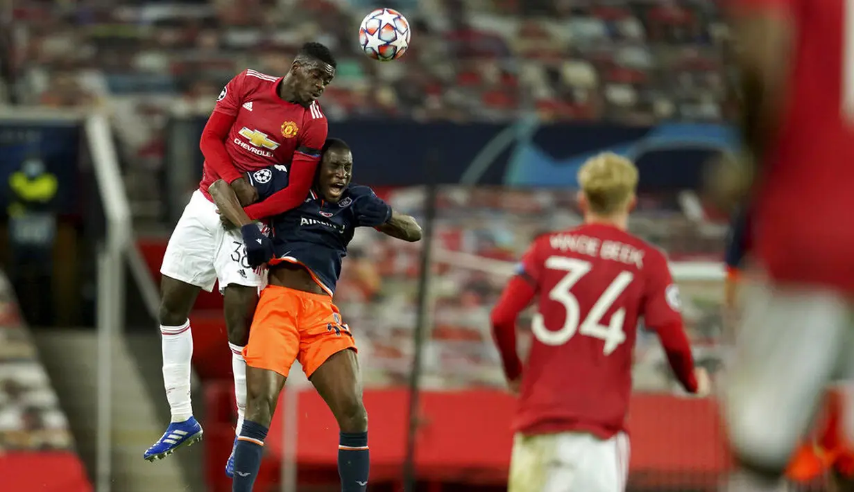 Pemain Istanbul Basaksehir, Demba Ba, duel udara dengan pemain Manchester United, Axel Tuanzebe, pada laga Liga Champions di Stadion Old Trafford, Rabu (25/11/2020). Setan Merah menang dengan skor 4-1. (AP/Dave Thompson)