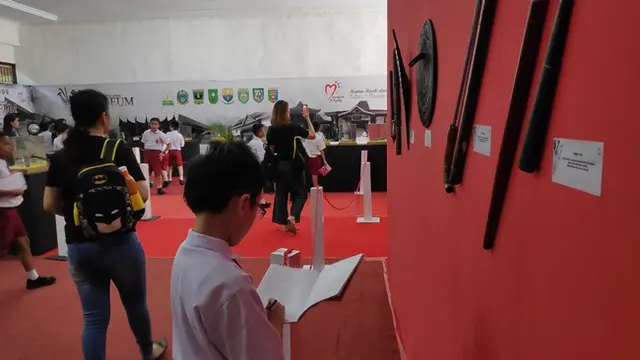 Murid SD yang berkunjung ke Museum Sang Nila Utama Riau mencatat nama koleksi yang ada.