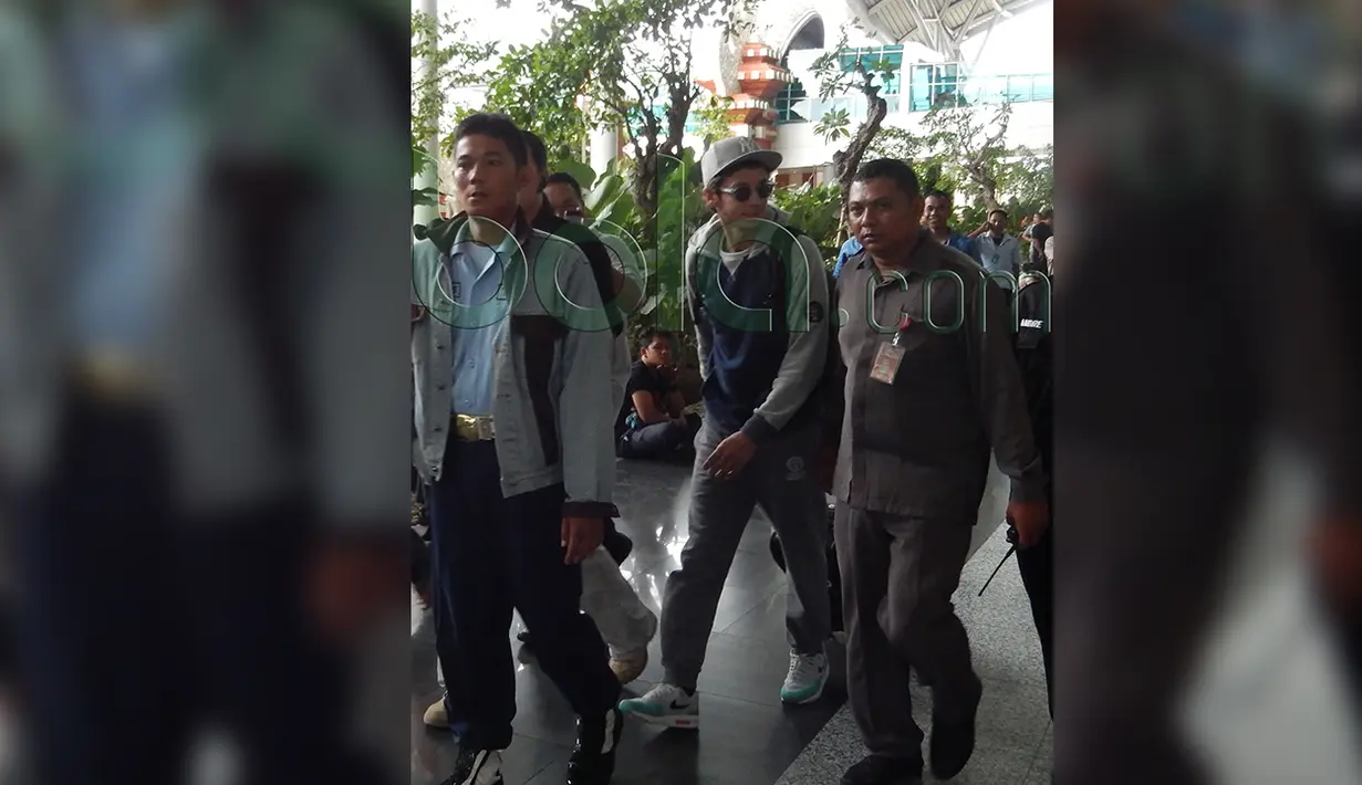 Beberapa petugas mengawal Valentino Rossi saat tiba di Bandara Ngurah Rai, Denpasar, Bali, Senin (25/1/2016). (Bola.com/Eksklusif)