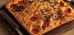 Focaccia bisa dihidangkan dengan berbagai jenis topping, seperti tomat dan keju yang meleleh. (Foto/dok: Freepik)