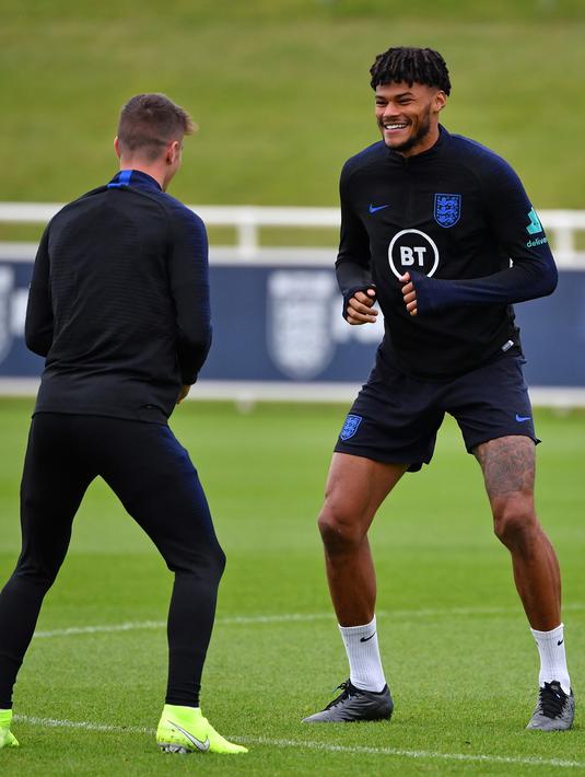 Bek Inggris Tyrone Mings (kanan) dan gelandang tengah Inggris Mason Mount (kiri) melakukan pemanasan saat mengikuti sesi latihan tim di St George's Park di Burton-on-Trent (6/9/2019). (AFP Photo/Paul Ellis)
