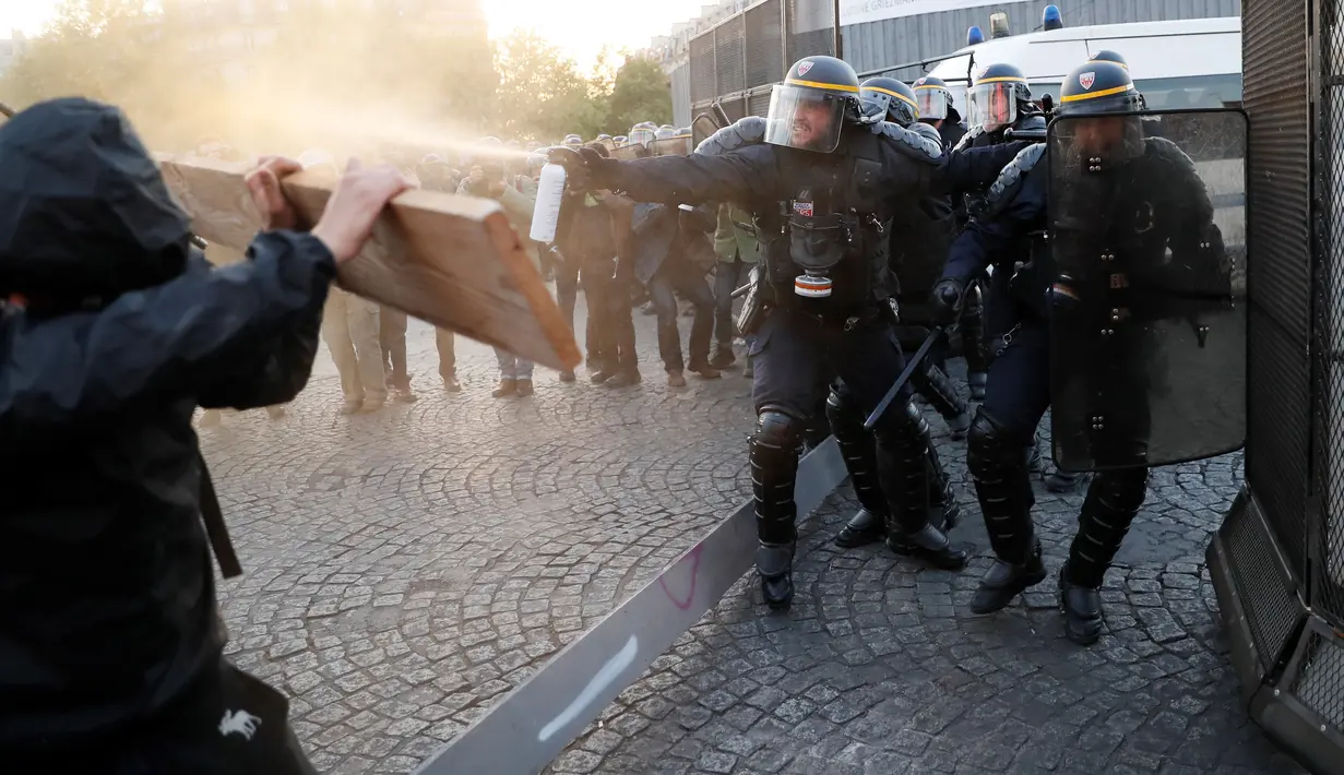 Bentrokan yang terjadi antara pasukan anti-huru hara dengan demonstran anti-fasis saat mereka menggelar aksinya di Paris (23/4). Mereka melakukan demo untuk menentang Le Pan dan kebijakan anti imigrasinya. (AFP/Thomas Samson)