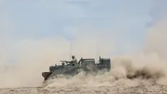 Seorang tentara Jerman menggunakan senapan mesin di atas kendaraan lapis baja saat mereka ikut serta dalam latihan militer bilateral Lituania-Jerman 'Badai Griffin' di Area Pelatihan Jenderal Silvestras Zukauskas di Pabrade, Lituania pada 26 Juni 2023. (AFP/PETRAS MALUKAS)