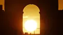 Foto yang diambil pada 2 Agustus 2022 menunjukkan Arc de Triomphe saat matahari terbenam, di Paris. Peristiwa yang dikenal sebagai "Paris Henge" ini di mana matahari sejajar dengan Champs Elysées, Arc de Triomphe dan Arche de la Défense. (Photo by Stefano RELLANDINI / AFP)