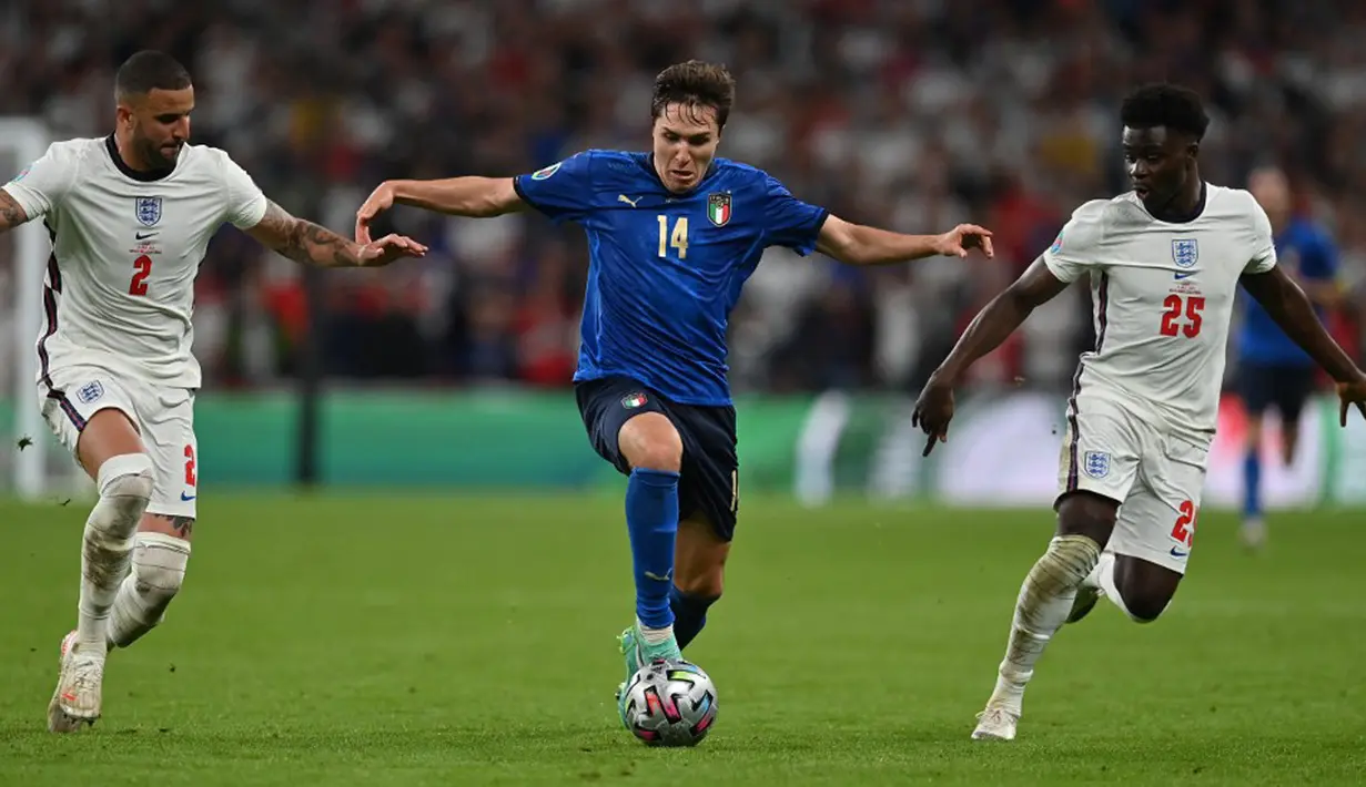 Pemain Italia Federico Chiesa (tengah) menggiring bola melewati pemain Inggris Kyle Walker (kiri) dan Bukayo Saka (kanan) pada pertandingan final Euro 2020 di Stadion Wembley, London, Inggris, 11 Juli 2021. Pergerakannya begitu eksplosif di posisi sayap dan tak kenal lelah. (Paul ELLIS/POOL/AFP)